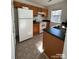 Efficient kitchen features a white refrigerator, electric range, wood cabinets, and laminate countertops at 1754 Pergola Pl, Charlotte, NC 28213