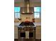 Close-up of a gourmet kitchen featuring a stainless steel oven with gas cooktop and herringbone backsplash at 180 Twin Sisters Ln, Mooresville, NC 28117