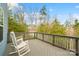 Inviting back deck with rocking chairs overlooking a serene view of trees and sky at 18607 Mainsail Ct, Lancaster, SC 29720