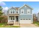 Charming two-story home showcasing blue siding, stone accents, and a welcoming front porch at 18607 Mainsail Ct, Lancaster, SC 29720