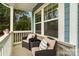 Relaxing wicker chairs adorned with pillows and a small table on a quaint front porch at 18607 Mainsail Ct, Lancaster, SC 29720