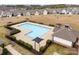 Aerial view of a community pool with umbrellas and seating, surrounded by manicured landscaping in a residential area at 18607 Mainsail Ct, Lancaster, SC 29720