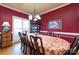 Elegant dining room with a chandelier, large table, and traditional decor with wainscoting and red walls at 205 Kaitlyn Ln, Kings Mountain, NC 28086