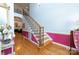 Bright foyer features hardwood floors, staircase with black iron railings and vibrant pink accent wall with white wainscoting at 205 Kaitlyn Ln, Kings Mountain, NC 28086