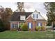 Charming brick home with blue shutters, dormer windows, a green door, and mature trees at 205 Kaitlyn Ln, Kings Mountain, NC 28086