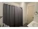 Cozy bathroom features a shower with gray textured curtain and a white paneled door at 216 W Shannonhouse St, Shelby, NC 28152