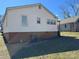 Rear exterior of home with neutral siding and visible foundation, featuring backyard greenery at 216 W Shannonhouse St, Shelby, NC 28152