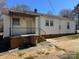 Rear exterior view, featuring siding, foundation, access steps, and backyard features at 216 W Shannonhouse St, Shelby, NC 28152