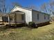 Side view of home featuring neutral siding and a covered porch with decorative iron supports at 216 W Shannonhouse St, Shelby, NC 28152