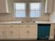 Renovated kitchen boasts white cabinetry, stainless steel sink, modern countertops, and updated fixtures at 216 W Shannonhouse St, Shelby, NC 28152