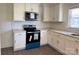 Modern kitchen featuring white cabinets, subway tile backsplash, new stainless steel microwave and range at 216 W Shannonhouse St, Shelby, NC 28152