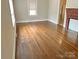 A cozy living room featuring gleaming hardwood floors and a classic brick fireplace at 220 Valleyview Pl, Salisbury, NC 28144