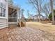 This backyard features a patio area with an elevated screened porch overlooking a grassy lawn at 2300 Bonnie Butler Way, Charlotte, NC 28270