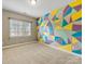 This bedroom has neutral walls and carpet and a colorful geometric accent wall at 2300 Bonnie Butler Way, Charlotte, NC 28270