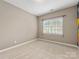 This bedroom has neutral walls and carpet and features a window at 2300 Bonnie Butler Way, Charlotte, NC 28270