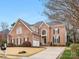 A traditional brick home features beautiful architectural details, a well-manicured lawn, and a two-car garage at 2300 Bonnie Butler Way, Charlotte, NC 28270
