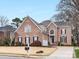A traditional brick home features beautiful architectural details, a well-manicured lawn, and a two-car garage at 2300 Bonnie Butler Way, Charlotte, NC 28270
