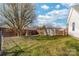 A well-maintained backyard featuring a privacy fence, large shade tree, and a storage shed at 2359 Eagle Glen Ct, Gastonia, NC 28056