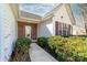 A close-up view of the charming front entrance with brickwork, white siding, and landscaped shrubbery at 2359 Eagle Glen Ct, Gastonia, NC 28056