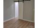 Neutral bedroom featuring a barn door and light wood-look flooring at 2545 Stockbridge Dr, Charlotte, NC 28210