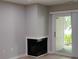 Corner fireplace in a cozy living room leading to a sliding glass door for outdoor access at 2545 Stockbridge Dr, Charlotte, NC 28210