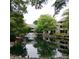 Community pond with water fountain surrounded by condos, trees, and greenery at 2545 Stockbridge Dr, Charlotte, NC 28210