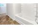 This bathroom features a white tub with shower and vinyl flooring at 2609 Riley Woods Ln, Charlotte, NC 28269