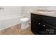 A bathroom with dark cabinets, granite vanity, and vinyl flooring at 2609 Riley Woods Ln, Charlotte, NC 28269