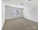 This carpeted bedroom has a neutral palette, with windows for natural light at 2609 Riley Woods Ln, Charlotte, NC 28269