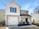 Charming two-story home features a one-car garage and inviting front porch with manicured landscaping at 2609 Riley Woods Ln, Charlotte, NC 28269