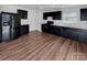 A beautifully designed kitchen features dark cabinets, stainless appliances and wood flooring at 2609 Riley Woods Ln, Charlotte, NC 28269