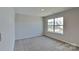 Bedroom with neutral walls and carpeting and a bright window overlooking the neighborhood at 299 Berrybeth Cir, China Grove, NC 28023