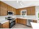 A kitchen with stainless appliances, wood cabinets, white countertops, and plenty of natural light from the window at 331 Don Mccarter Dr, Clover, SC 29710
