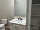 Bathroom features a vanity with a mirror, speckled countertop and a toilet next to a shelf at 3342 York Hwy, Gastonia, NC 28052