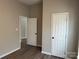 Bedroom featuring wood-look floors, two white doors and a view into an adjacent room at 3342 York Hwy, Gastonia, NC 28052