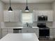 Modern kitchen featuring white cabinets, quartz countertops, stainless appliances, and sleek black pendant lighting at 3342 York Hwy, Gastonia, NC 28052