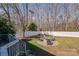 Expansive backyard with a white fence, mature trees, and a brick patio with a fire pit and seating at 4107 Balsam St, Indian Trail, NC 28079