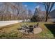 Large backyard with a well-maintained lawn, a white fence, and a brick patio with outdoor furniture around a fire pit at 4107 Balsam St, Indian Trail, NC 28079