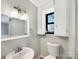 Cozy bathroom with pedestal sink, mirror, toilet, and window at 414 N Wylie St, Lancaster, SC 29720
