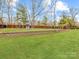 Large grassy backyard lawn area, brick retaining wall, fence, and playset at 4624 Pebble Run Dr, Matthews, NC 28105