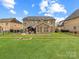 View of backyard, backyard brick patio, gazebo, firepit and lush green lawn at 4624 Pebble Run Dr, Matthews, NC 28105