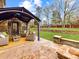 Backyard brick patio and furniture with retaining wall and stairs to backyard lawn and play set at 4624 Pebble Run Dr, Matthews, NC 28105