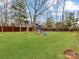 Backyard lawn area with play set and privacy fence at 4624 Pebble Run Dr, Matthews, NC 28105