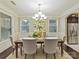 Formal dining room with a chandelier, neutral walls, large window and hardwood flooring at 4624 Pebble Run Dr, Matthews, NC 28105