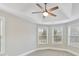 An empty bedroom featuring a tray ceiling with fan and two windows bringing in lots of natural light at 4624 Pebble Run Dr, Matthews, NC 28105