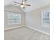 An empty bedroom has a vaulted ceiling with a ceiling fan and large windows to let the sunshine in at 4624 Pebble Run Dr, Matthews, NC 28105