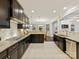 Spacious kitchen with dark wood cabinets, granite counters, stainless steel appliances, and tile flooring at 4624 Pebble Run Dr, Matthews, NC 28105