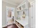 Mudroom with storage bench, hooks, and built-in shelving leading to a bathroom at 4624 Pebble Run Dr, Matthews, NC 28105