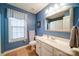 Classic bathroom with a blue wall, shower, and vanity with sink and a large mirror at 4763 River Hills Dr, Denver, NC 28037