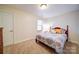Neutral bedroom with carpet, a bed with colorful pillows, and a small dresser at 4763 River Hills Dr, Denver, NC 28037